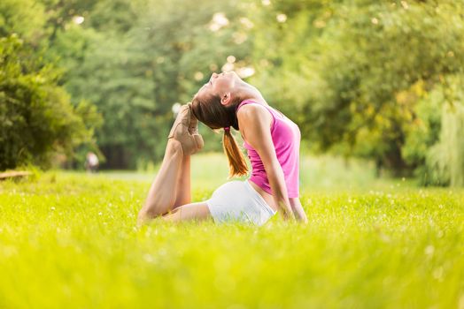 Young woman practicing yoga in the park.