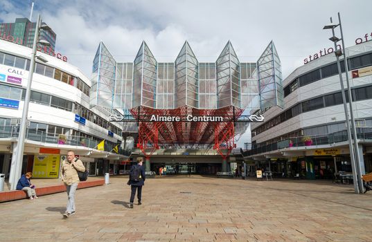 Almere, Netherlands - May 5, 2015: People visit Almere Central Station on May 5, 2015 in Almere, Netherlands. The station opened may 1987 and is designed by Peter Kilsdonk. Under the station lies a bus station