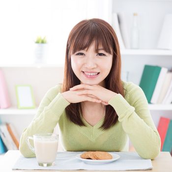 Portrait of happy Asian girl eating breakfast. Young woman indoors living lifestyle at home.