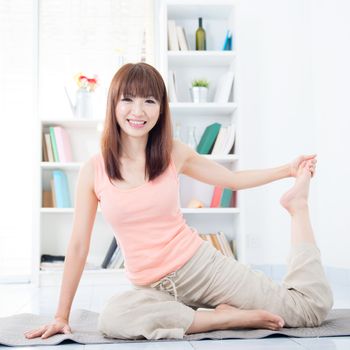 Happy Asian girl stretching and yoga in the morning. Young woman indoors living lifestyle at home.
