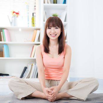 Happy Asian girl doing yoga in the morning. Young woman indoors living lifestyle at home.