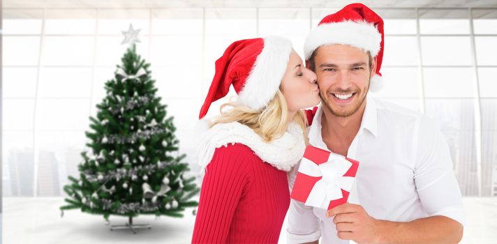 Young festive couple against home with christmas tree