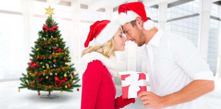Young festive couple against home with christmas tree