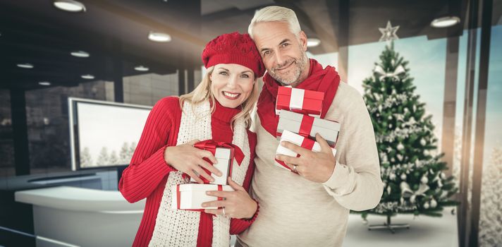 Happy festive couple with gifts against home with christmas tree