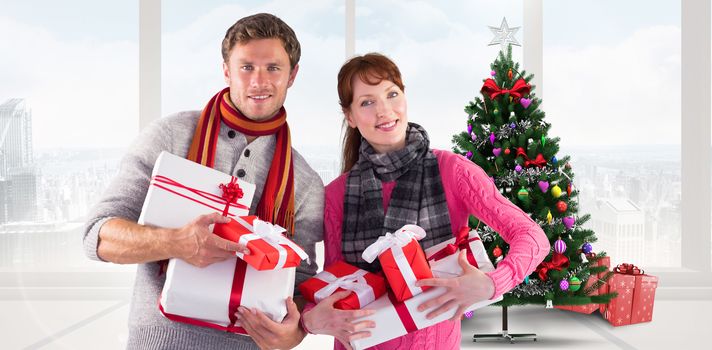 Couple holding lots of presents against home with christmas tree