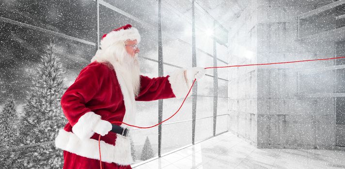 Santa pulls something with a rope against window overlooking snowy forest