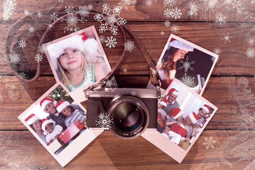 Girl wearing Santa hat at home against instant photos on wooden floor