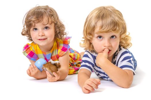 Funny boy and girl are lying together isolated on white background. Focus on little boy.