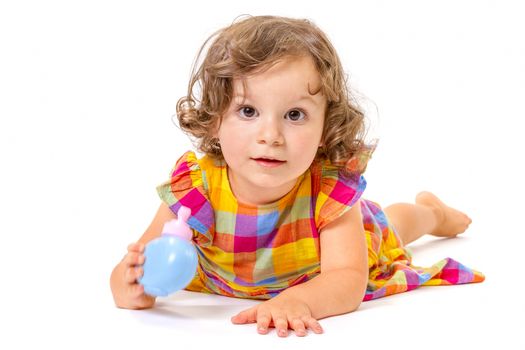 Cheerful little girl smiling at camera lying on white background.