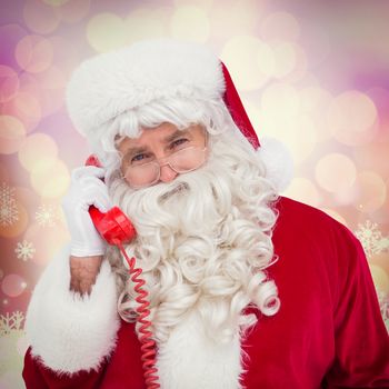 Santa claus on the phone  against glowing christmas background