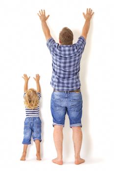 Father and son standing with their backs to the camera with hands up. Growing up concept.