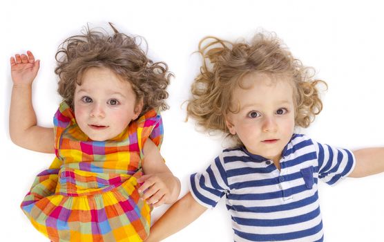  Little boy and girl looking at camera on white background