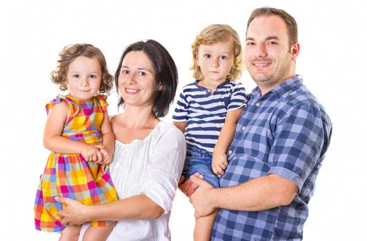 Happy family of four smiling while standing against white background.
