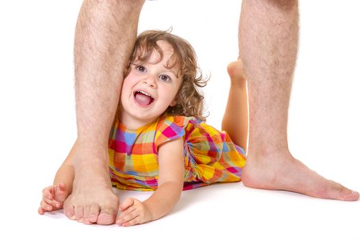 Little daughter feeling happy and protected at the feet of her father