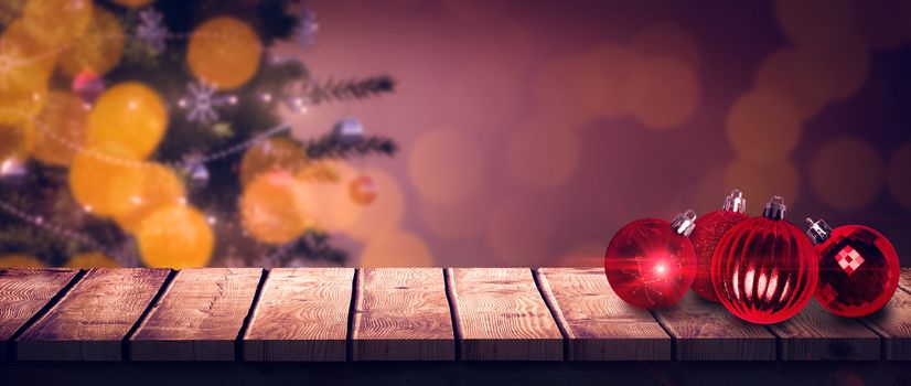 Wooden desk against christmas baubles