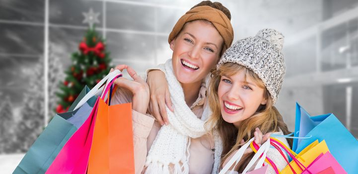 Smiling women looking at camera with shopping bags  against home with christmas tree