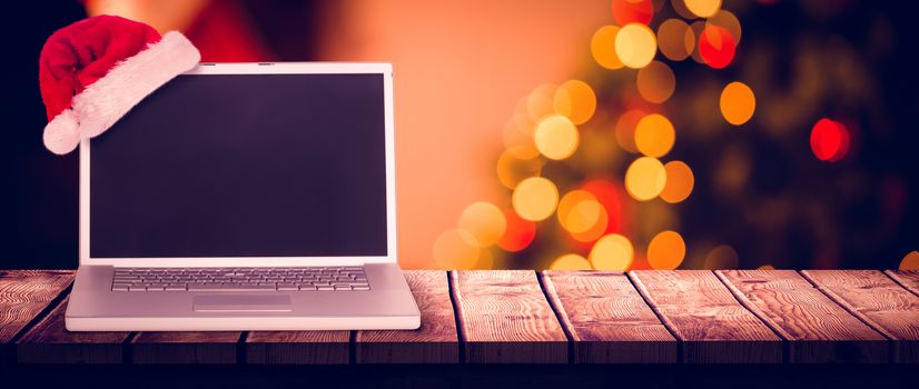 christmas laptop against desk with christmas tree in background