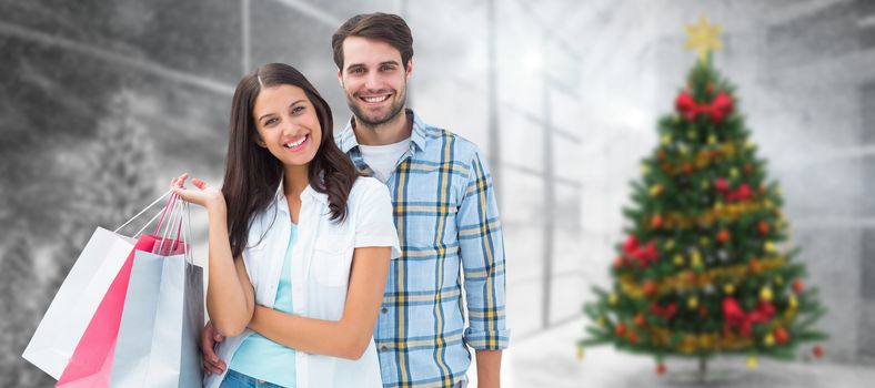 Happy couple with shopping bags against home with christmas tree