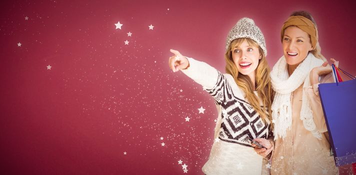 Beautiful women holding shopping bags pointing  against red background