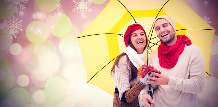 Autumn couple holding umbrella against glowing christmas background