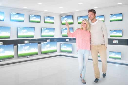 Attractive couple smiling and walking against televisions for sale