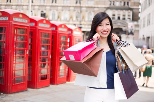young Japanese woman in london with shopping bags