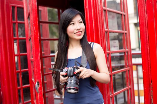 japanese tourist in london holding her camera