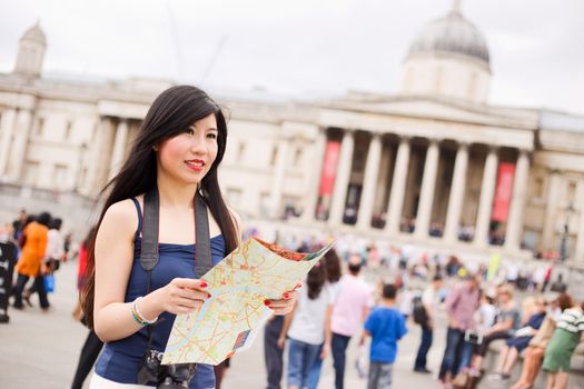 japanese tourist in Trafalgar square holding a map