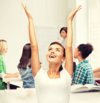 education and success concept - happy student girl with hands up