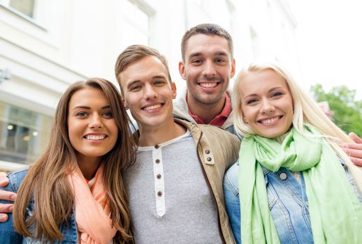 travel, vacation and friendship concept - group of smiling friends in city