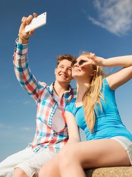 holidays, vacation, love and friendship concept - smiling couple having fun outdoors