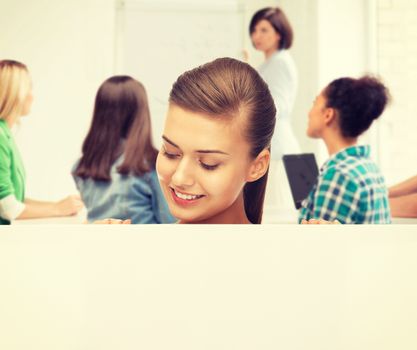 education concept - smiling student girl with white blank board