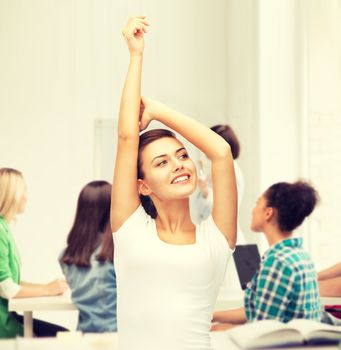 education and success concept - happy student girl with hands up