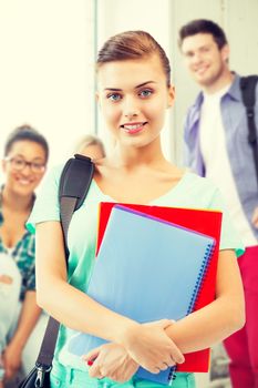 happy student girl with school bag and notebooks at school