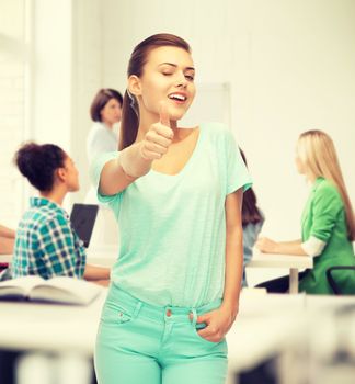 smiling girl in color t-shirt showing thumbs up at school