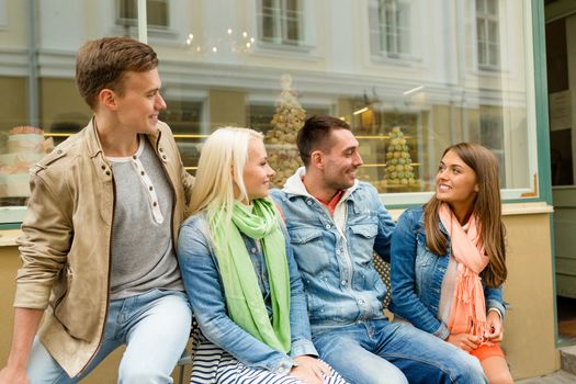 friendship, travel and vacation concept - group of smiling friends in the city