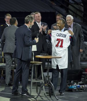 US, Virginia: Republican presidential candidate Dr Ben Carson addressed a packed room at the Liberty University in Virginia, on November 11, 2015. The retired neurosurgeon talked about his upbringing and his experience as a doctor in front of a crowd of nearly 12,000 people.  Pictured President of Liberty University Jerry Falwell gives Dr. Carson a jersey 