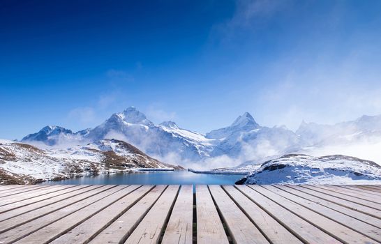 snow peaks of Jungfrau region grindelwald switzerland with wooden terrace