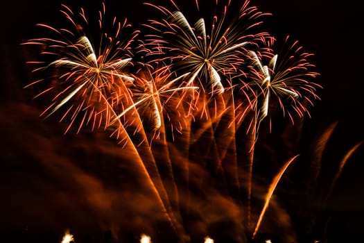 Colorful fireworks of various colors over night sky with spectators