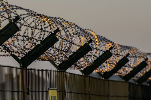 Military fence with a barbed wire