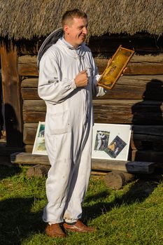 CHORZOW, POLAND, OCTOBER 21: Beekeeper showing honeycomb frame during Day of Honey in the Cottage Museum on October 21, 2012, in Chorzow