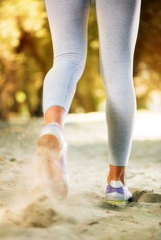 Rear view of woman jogging in nature. Close-up.