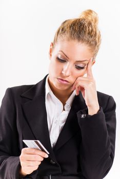 Businesswoman holding a credit card and thinking.