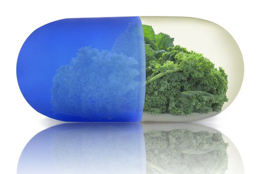 Close up of a vitamin pill with green vegetables including kale, cabbage and lettuce