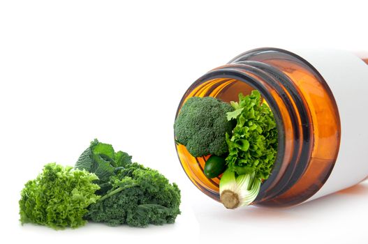 Fresh green detox vegetables including kale inside a medicine jar over a white background