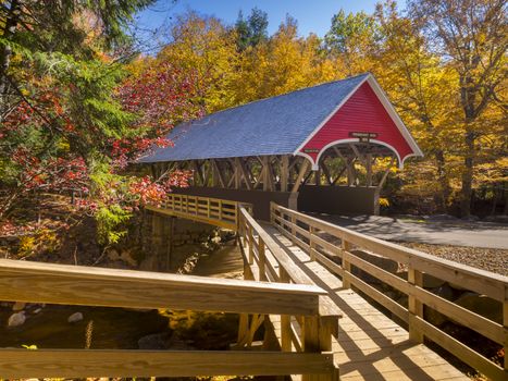 Red covered bridge in Fanconia New Hampshire during Fall season