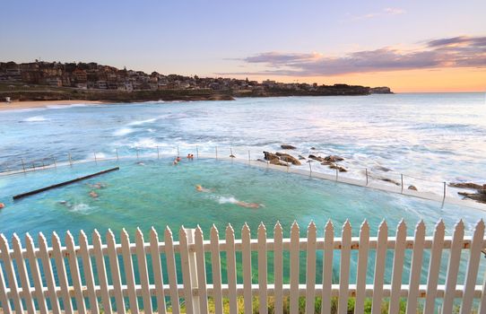 Just after sunrise looking north east across Bronte Baths while people enjoy an early morning swim before work.