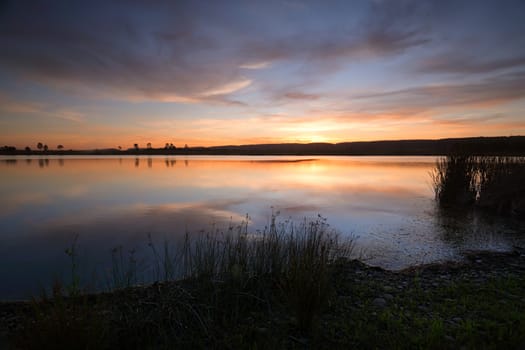 Soft peachy oranges, aqua blues and soft lemons decorate the sky as the sun sinks behind the Blue Mountains and ever still waters perfectly reflect the sky above.  Duralia Lake Penrith