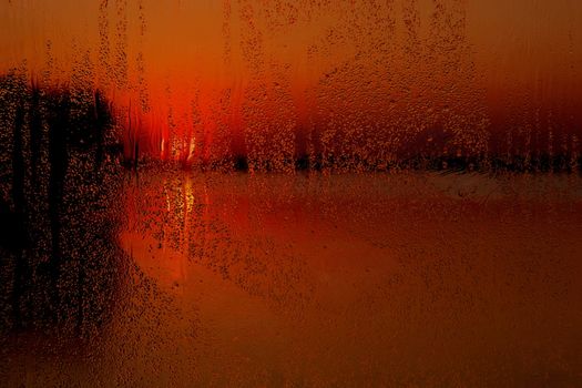 Rainy window at sunset