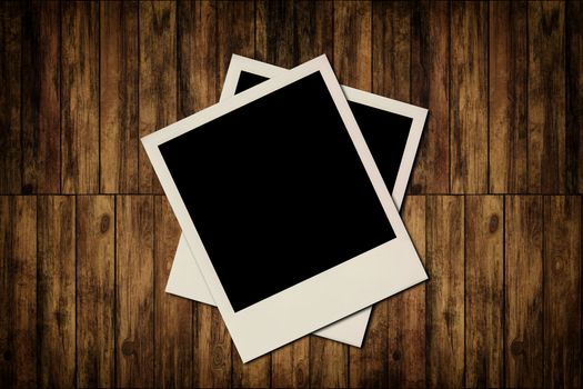 Blank instant photo frames on old wooden background